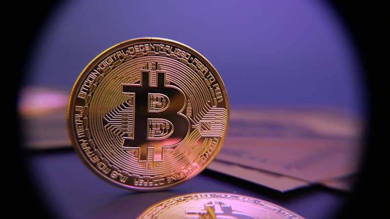 Bitcoin coin displayed on a purple background.